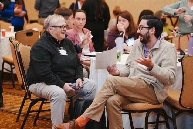 Two conference guests, sit and enjoy talking to each other